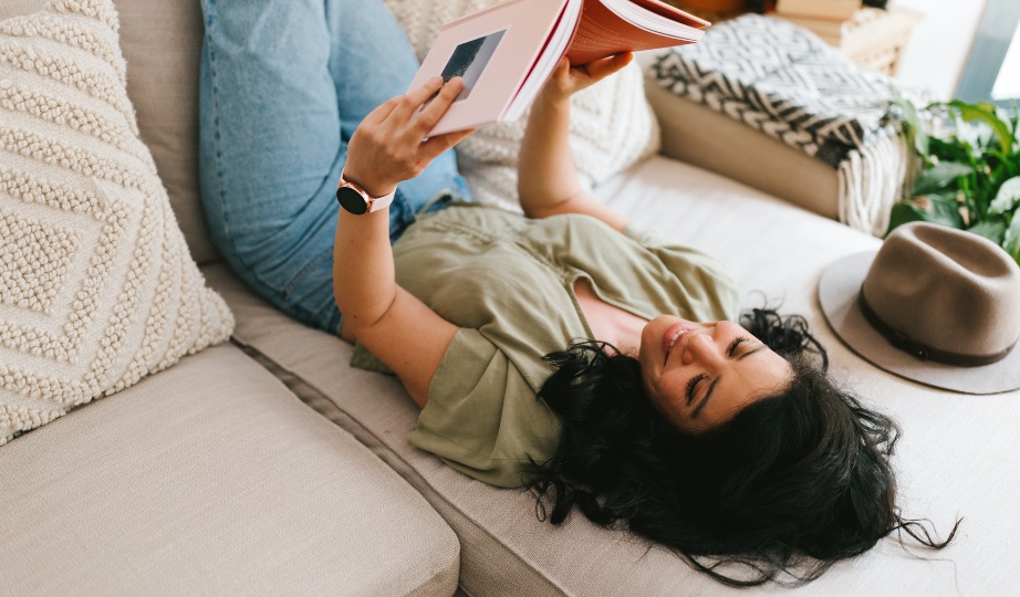 Woman looking at a book on the couch