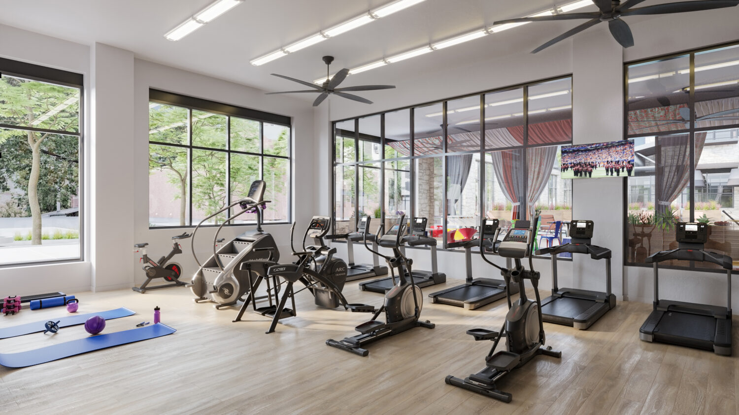 Fitness center with cardio machines, yoga mats, treadmills, and ceiling fans